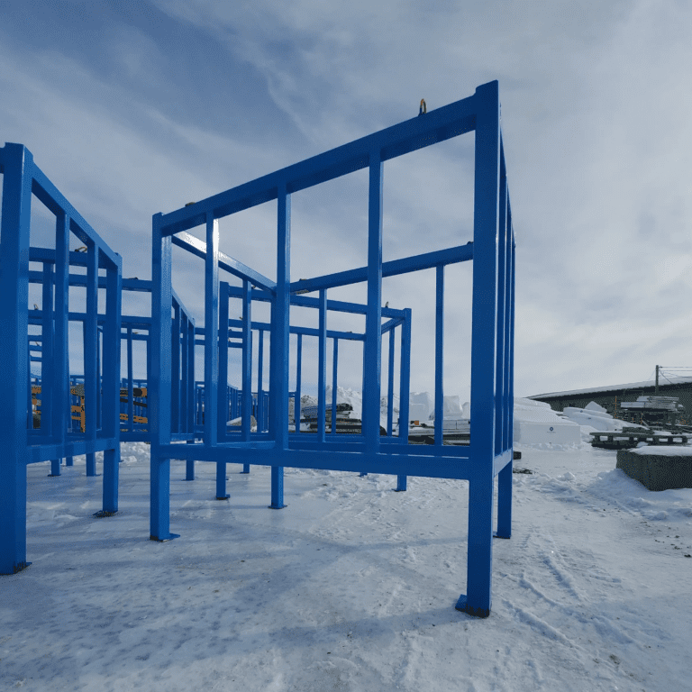 Structures de stockage industrielles peintes en bleu, disposées en plein air sur un sol enneigé, probablement utilisées pour la gestion de matériaux ou le stockage en extérieur dans un contexte industriel ou de construction.