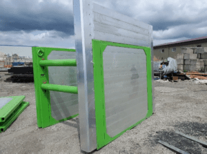 Porte de sécurité industrielle en métal bicolore, avec une base verte et des barres horizontales argentées, renforcée pour résister dans un environnement de travail exigeant.