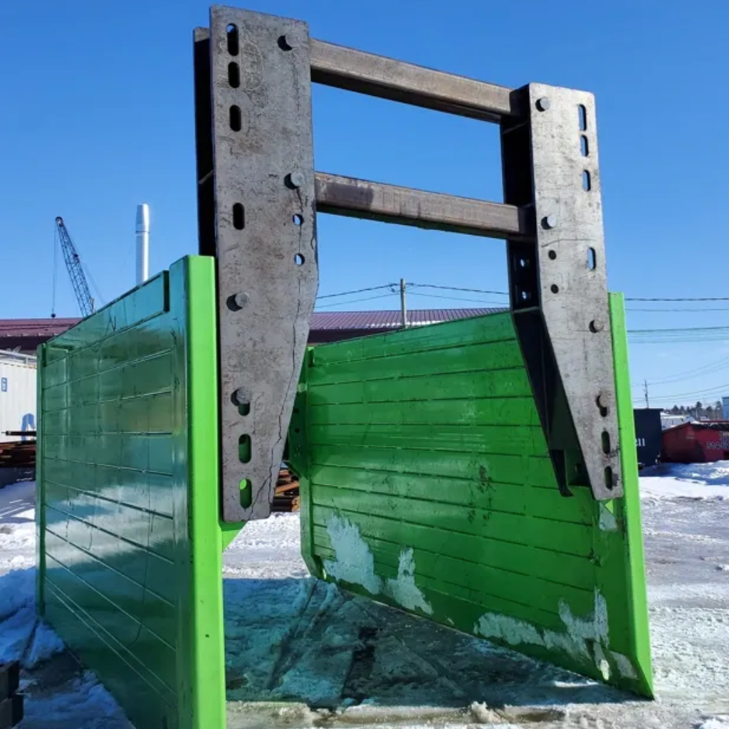 Un équipement d'étançonnement en métal peint en vert se tient debout sur un sol enneigé. La structure robuste avec des trous de fixation suggère sa capacité à soutenir de lourdes charges, typique des chantiers de construction.